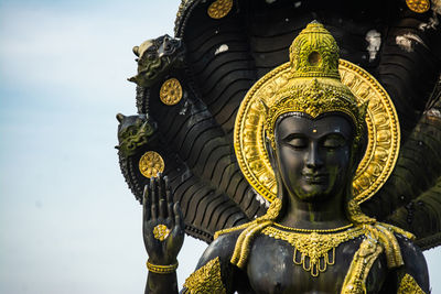 Low angle view of buddha statue against building