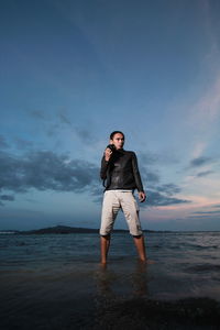 Man standing in sea against sky