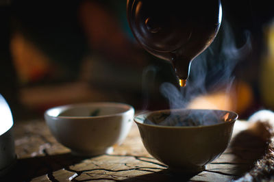 Close-up of herbal tea being poured in cup