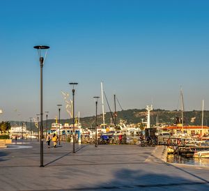 Sailboats in harbor against clear sky