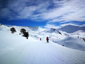 People skiing on snowcapped mountain against sky