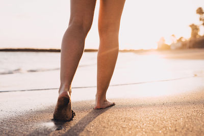 Low section of woman standing on road