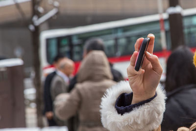 Close-up of woman hand photographing with mobile phone in city