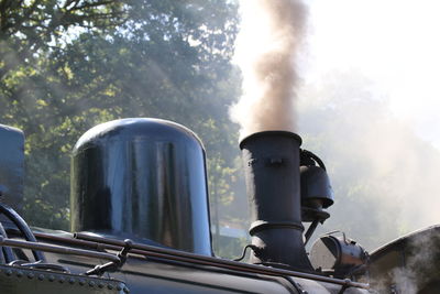 Low angle view of smoke emitting from chimney against sky