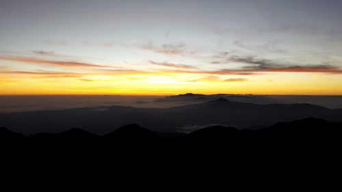 Scenic view of silhouette mountains against sky during sunset