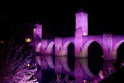 Illuminated building against sky at night