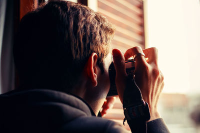 Rear view of man using mobile phone