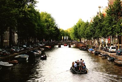 Boats in river with city in background