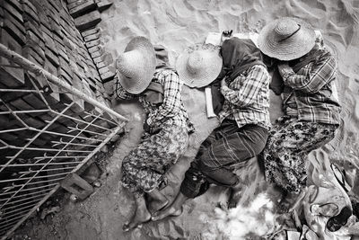 High angle view of female workers relaxing on sand at construction site