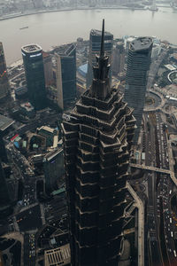 From above aerial view of famous landmark skyscraper jin mao tower located among contemporary high rise buildings at river waterfront in shanghai