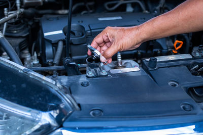 Cropped hand of man repairing car