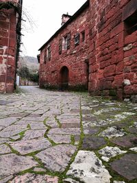 Walkway amidst stone wall against sky