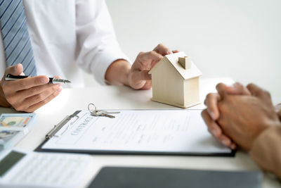 Midsection of man holding paper at table