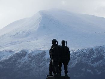 Tourists on snow covered mountain