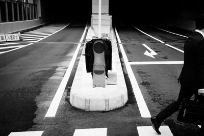 Rear view of man walking by road signal on street