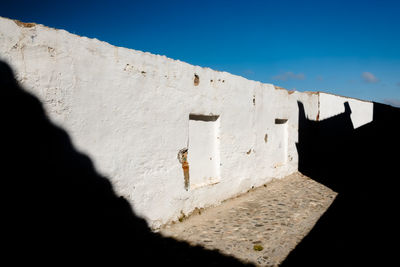 Low angle view of wall against blue sky