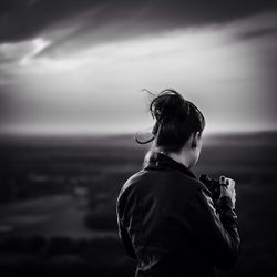 Rear view of woman standing against sky