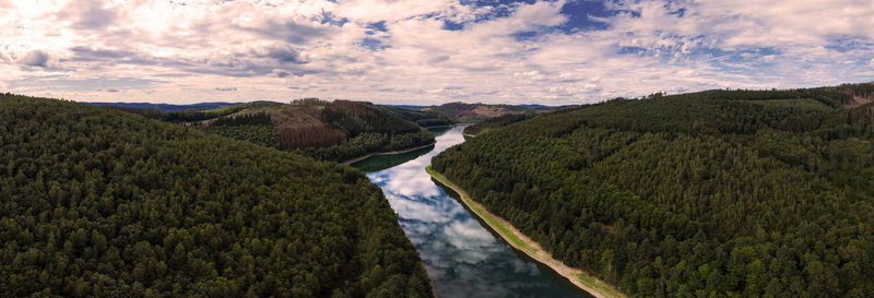 Panoramic view of river amidst mountains against sky