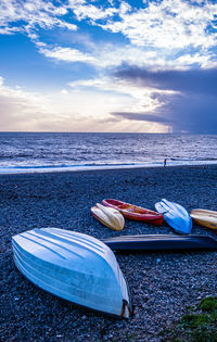 Boat moored on beach against sky