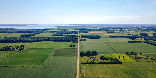 A rural scene of wisconsin farms during summer with lake winneconnie in the background