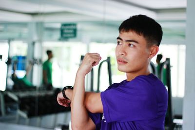 Thoughtful young man exercising at gym