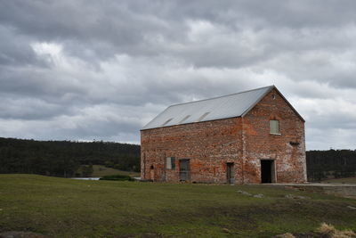 Abandoned building on field against sky