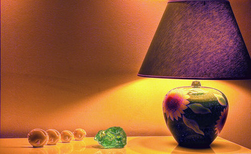 Close-up of illuminated lamp on table against wall at home