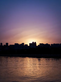 Silhouette buildings against sky during sunset