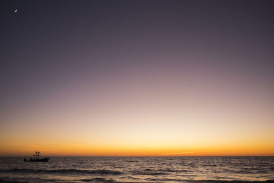 Scenic view of sea against clear sky during sunset