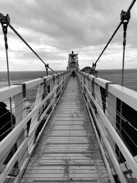 View of pier on sea against cloudy sky