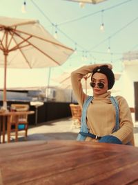 Portrait of young woman wearing sunglasses sitting outdoors