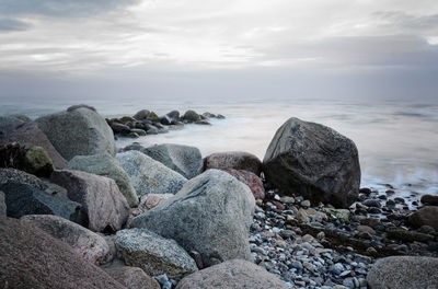 Rocks on beach against sky