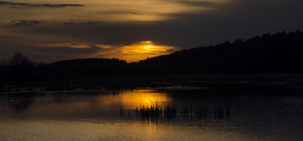 Scenic view of lake against orange sky