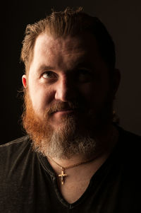 Close-up portrait of man against black background