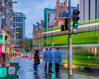 People walking on city street during rainy season
