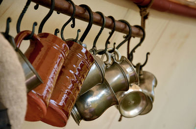 Low angle view of cups hanging on hooks in kitchen