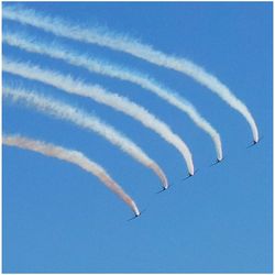 Low angle view of vapor trail against clear blue sky