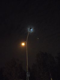 Low angle view of illuminated street light against sky