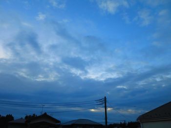 Low angle view of silhouette electricity pylon against sky