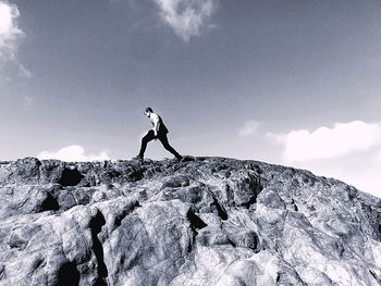 Low angle view of man on rock against sky