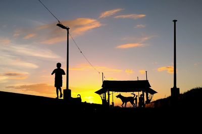 Silhouette man standing against sky during sunset