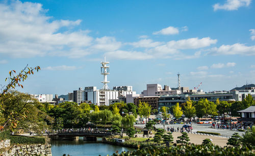 River amidst buildings in city against sky