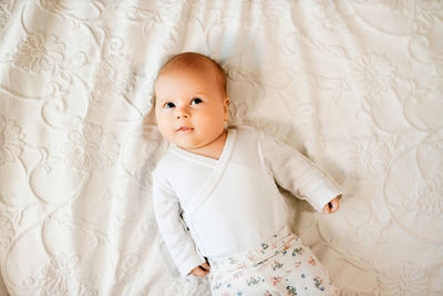 Cute baby girl lying on bed