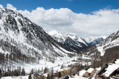 Scenic view of snow covered mountains against cloudy sky