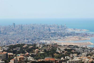 High angle view of townscape by sea against sky