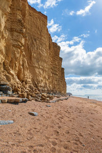 Rock formations on beach against sky