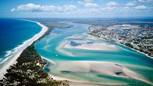 Aerial view of sea and city against sky