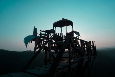 Traditional windmill on mountain against clear sky