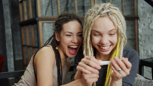 Portrait of happy young woman holding smart phone