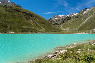 Scenic view of lake by mountains against sky